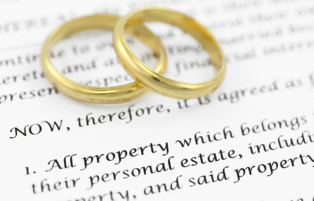 Form of prenuptial agreement with a pair of wedding rings. Shallow DOF on the word PROPERTY.