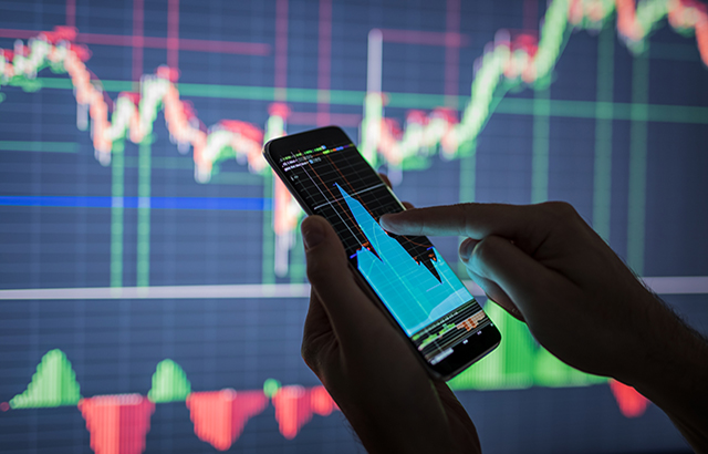 Businessman checking stock market data. He using a mobile phone. Analysis economy data on forex earn graph.