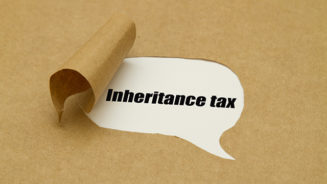 Inheritance tax written under torn paper.