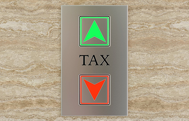 Engraved label TAX between up and down lift buttons on a marble wall. Illustration of the concept of tax and self assessment
