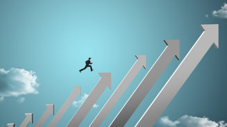 businessman jumping on growing chart with sky background