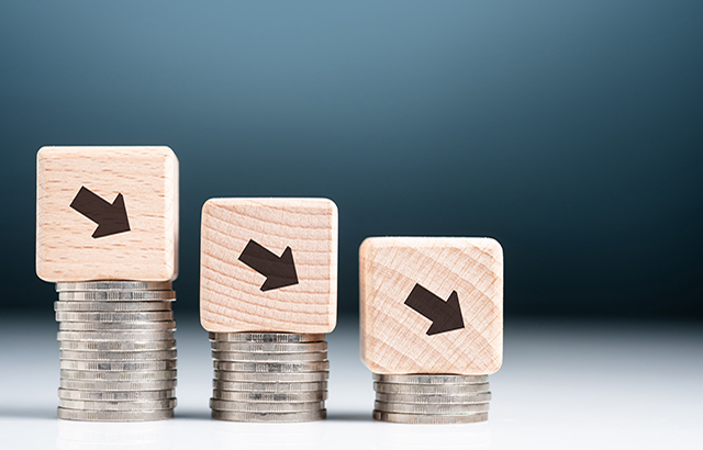 Descending finance graph, decrease coins heap with arrow sign on wood block as graph symbol, business and econnomic recession, credit decrease or less saving money